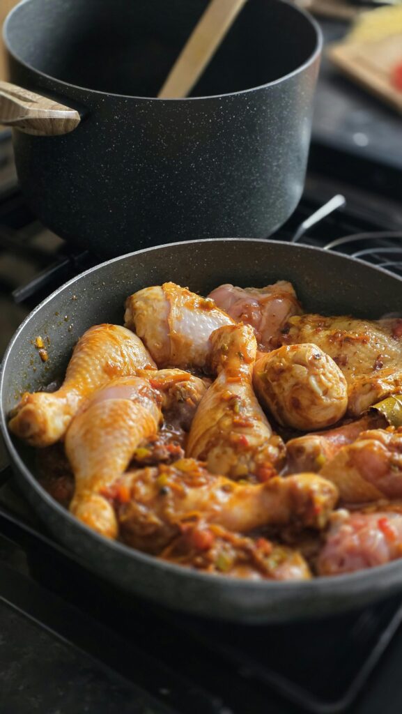 Succulent chicken drumsticks simmering in spices on the stovetop, ready to serve.